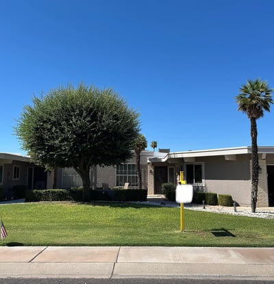 Attractive Sun City exterior featuring green lawn, shade trees, and inviting curb appeal that enhances the home's overall charm.