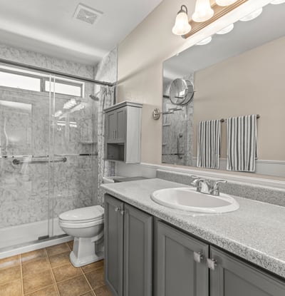 Updated bathroom featuring a walk-in shower, extended vanity, and contemporary finishes. Clean, bright, and move-in ready.