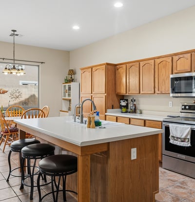 Well-designed kitchen with large island, breakfast seating, and generous cabinet storage, ideal for hosting and daily use in Phoenix.
