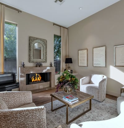 Sun-filled living room featuring designer d cor, a sleek fireplace, and large windows that enhance the open feel of this Phoenix home.