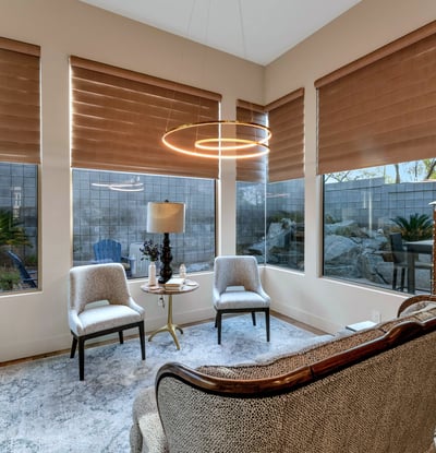Cozy seating area surrounded by windows, offering abundant natural light and a relaxing ambiance in this Phoenix property.