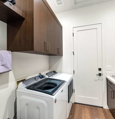 Efficient laundry space with built-in cabinets, sink, and modern washer and dryer, adding practicality to this Phoenix residence.
