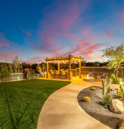 Beautifully designed Scottsdale backyard with manicured grass, desert landscaping, and pergola space ideal for relaxing or entertaining.