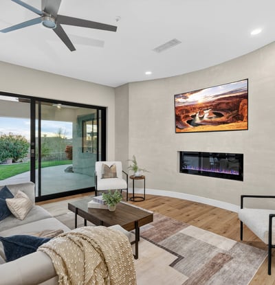 Contemporary living room with ceiling fan, neutral tones, and direct patio access, highlighting Scottsdale modern living and outdoor connection.
