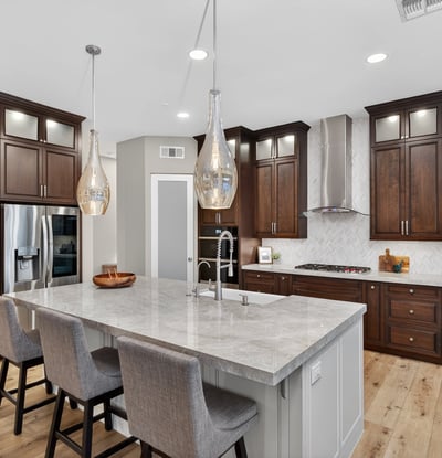 High-end kitchen with quartz island, farmhouse sink, custom cabinetry, and stainless steel appliances in this Scottsdale home.