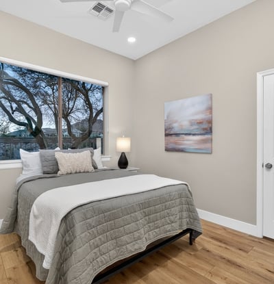Peaceful Scottsdale bedroom with expansive window views, modern finishes, and wood flooring, ideal for relaxation.