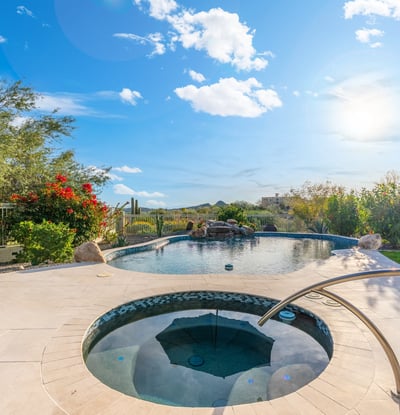 Scottsdale backyard with pool, spa, and lounge seating, surrounded by desert landscaping and designed for outdoor living.