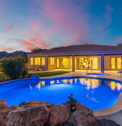 Scottsdale outdoor living with illuminated pool, spa, and covered patio, emphasizing modern updates and resort-style design.