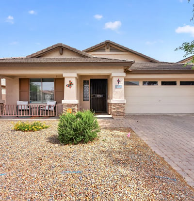 Attractive exterior with covered porch, desert landscaping, and attached garage. Clean curb appeal defines this Casa Grande property.
