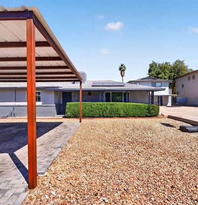 Clean front yard with gravel landscaping and covered parking, designed for durability and ease in this Phoenix multi-unit home.