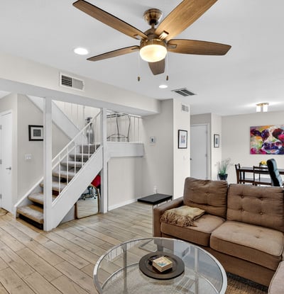 Spacious Scottsdale living area with tile flooring, ceiling fan, and open flow to dining and patio, perfect for comfortable everyday living.
