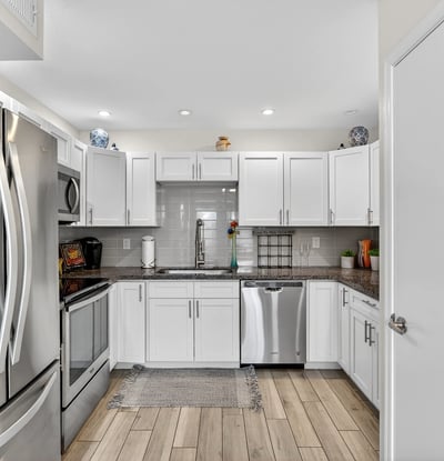 Contemporary kitchen in Scottsdale with stainless appliances, white cabinets, and tile backsplash offering both style and functionality.