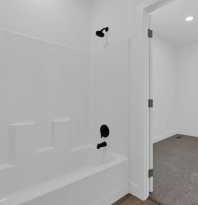 Freshly finished bathroom featuring a full bathtub, shower, modern tile accents, and updated hardware. Clean lines and neutral finishes create a timeless look that appeals to today's buyers.