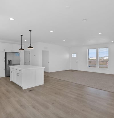 Large living and dining area flowing effortlessly into the kitchen, creating a versatile space for everyday living. The spacious floor plan highlights the home's modern design and comfortable functionality.