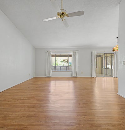 Designed for comfort and flexibility, this open living area features large windows, soaring ceilings, and abundant natural light. The layout seamlessly supports both everyday living and entertaining.