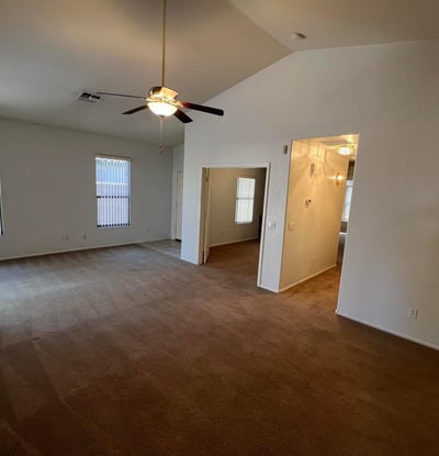 Bright and spacious living room offering vaulted ceilings, multiple windows, and flexible furniture placement options. The open layout enhances comfort while maximizing usable living space.