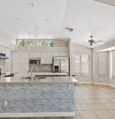 This bright kitchen offers updated cabinetry, newer countertops, stainless steel appliances, a large center island, and a sunny breakfast area. The open design provides an ideal setting for cooking, casual dining, and entertaining while enjoying seamless flow to the surrounding living spaces.