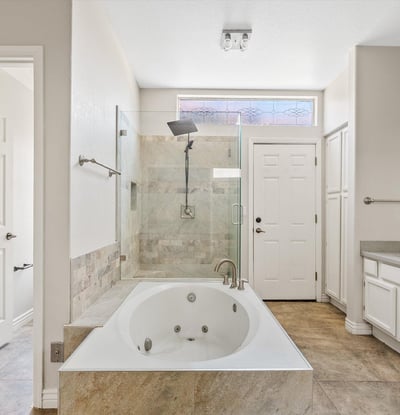 Relax in the spacious primary ensuite featuring a jetted soaking tub, oversized glass shower, updated fixtures, and abundant natural light. Thoughtfully designed for everyday comfort and luxury in Chandler.