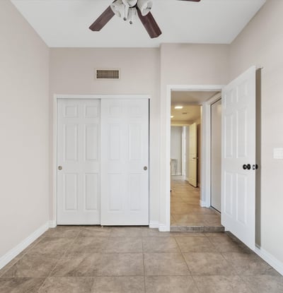 Featuring tile flooring, ceiling fan, and generous closet storage, this flexible bedroom easily accommodates guests, family, or a productive home office.