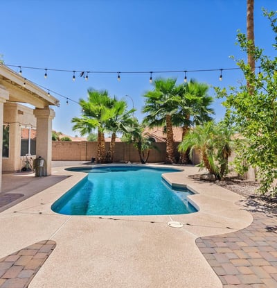 Enjoy outdoor living with a sparkling swimming pool, paver patio, mature palm trees, and covered patio. A wonderful setting for relaxing or entertaining in Chandler.