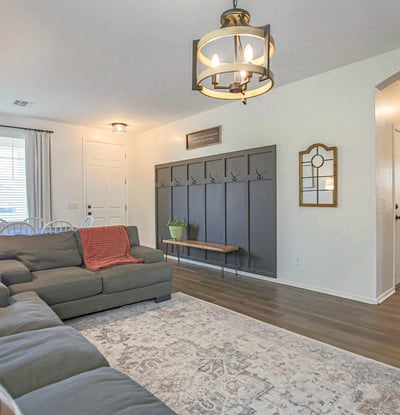 Stylish living room with luxury flooring, contemporary lighting, and a custom entry drop zone that adds organization and charm. A functional and inviting space for everyday living.