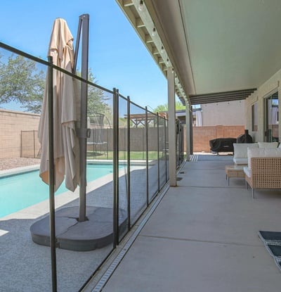 Spacious covered patio with cozy seating, pool views, and direct access to the backyard entertaining area. A relaxing outdoor extension of this beautiful Waddell home's living space.