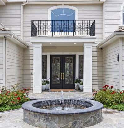 Elegant private entryway features a tranquil fountain and landscaped gardens, creating an inviting first impression.