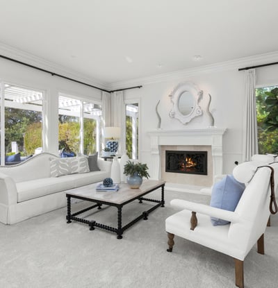 inviting living room featuring a cozy fireplace and large windows for abundant natural light.