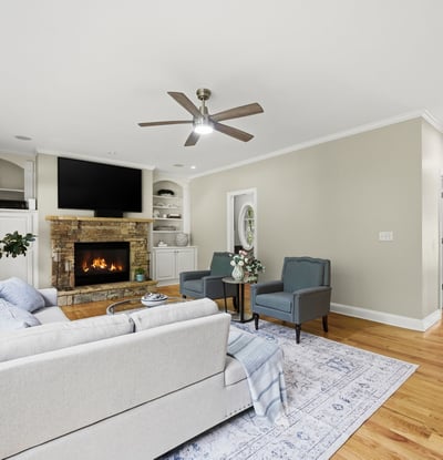 Spacious living area featuring a cozy fireplace, large windows, and modern finishes, ideal for gathering.