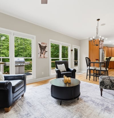 Spacious living area features large windows, modern kitchen amenities, and outdoor access for entertaining.
