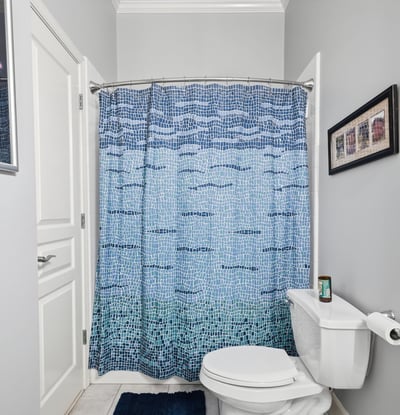 Bright and inviting bathroom featuring a colorful shower curtain and modern fixtures, perfect for daily use.
