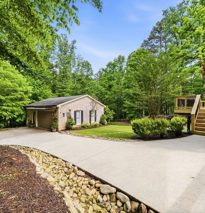 Spacious home nestled on a lush lot, featuring ample outdoor living space and a welcoming driveway.