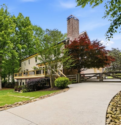 Discover a beautifully landscaped property featuring ample outdoor space and a welcoming driveway leading to the entrance.