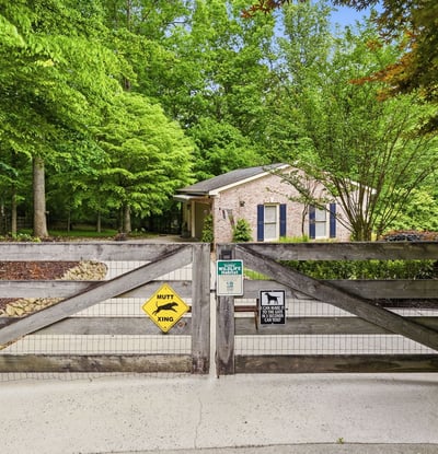 Nestled amid lush greenery, this property features a welcoming entrance and ample outdoor space for relaxation.