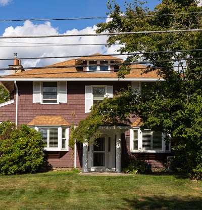 Spacious home featuring a well-maintained lawn, mature trees, and a welcoming entrance, perfect for family living.
