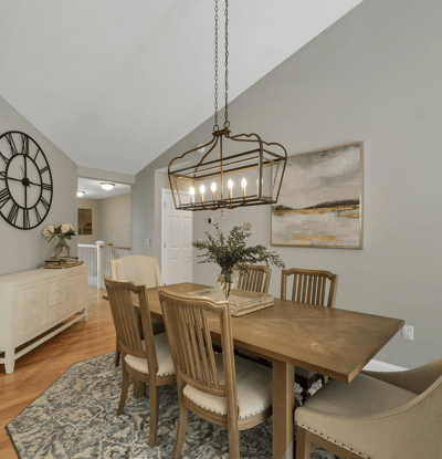 Bright dining area featuring vaulted ceilings, contemporary lighting, and a warm wood table, perfect for gatherings.