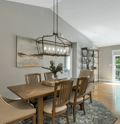 Bright dining area featuring a modern light fixture, perfect for intimate gatherings and open to lush views.