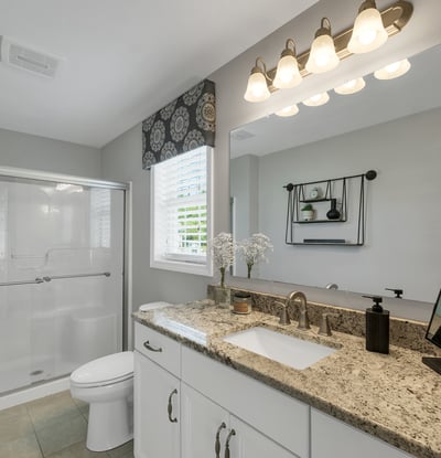 Bright and modern bathroom featuring a spacious countertop, sleek fixtures, and natural light from the window.