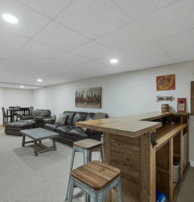 Spacious lower-level entertainment area featuring a bar, cozy seating, and ample space for gatherings.