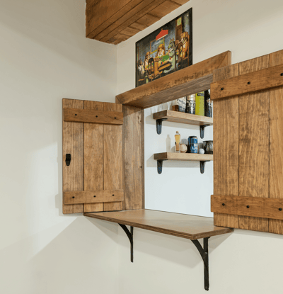 This unique nook features rustic wooden shutters and shelving, perfect for displaying decor or storing essentials.