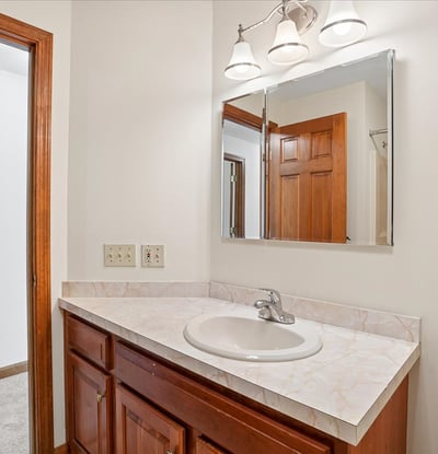 Bright bathroom featuring a spacious vanity with ample counter space and a convenient mirror overhead.
