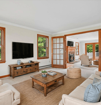 Spacious living room featuring large windows, a cozy fireplace, and a seamless flow to outdoor views.