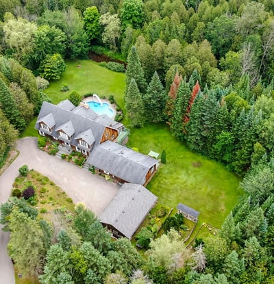 Discover a spacious retreat surrounded by lush greenery, featuring a swimming pool and expansive outdoor area.