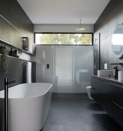 This modern bathroom features a sleek freestanding tub, stylish fixtures, and ample natural light for relaxation.