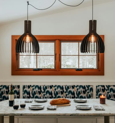 Bright and inviting kitchen nook featuring modern lighting, a spacious dining table, and cozy window seating.
