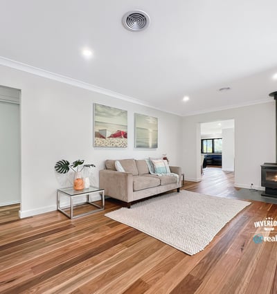 Spacious living area featuring hardwood floors and a cozy wood-burning stove, perfect for gatherings and relaxation.