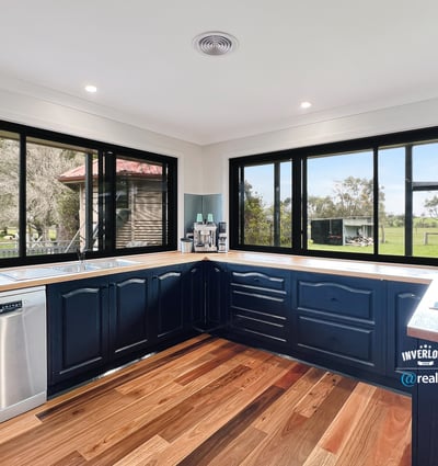 Modern kitchen with panoramic windows, featuring sleek cabinetry and scenic views of the surrounding landscape.
