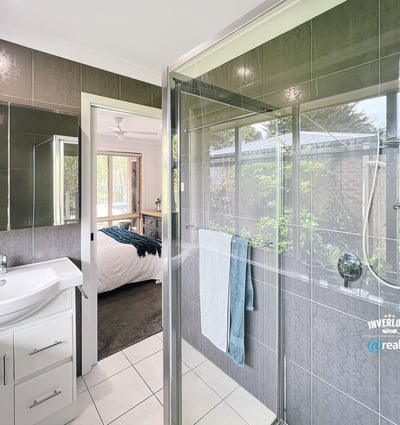 Modern bathroom featuring a spacious shower, sleek fixtures, and a seamless view of the landscaped garden.