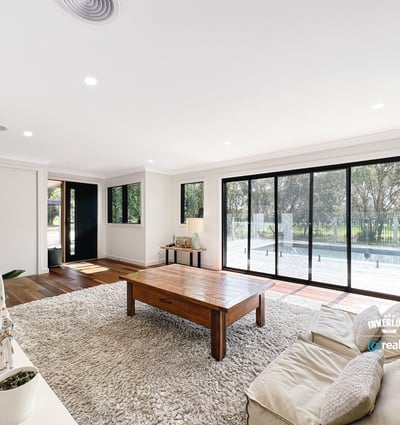 Spacious living area features large windows, abundant natural light, and direct access to outdoor spaces.