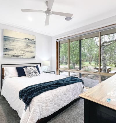 Bright bedroom with large windows offering scenic views and modern finishes for comfortable living.